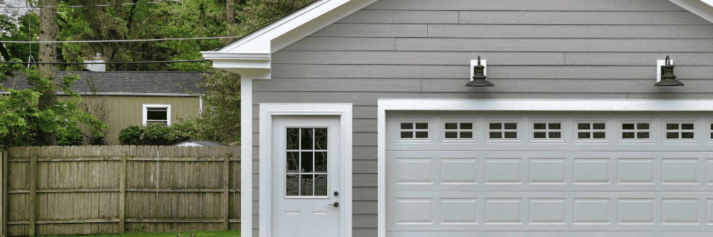 ett-gratt-garage-med-vit-garagedorr-och-vit-entredorr