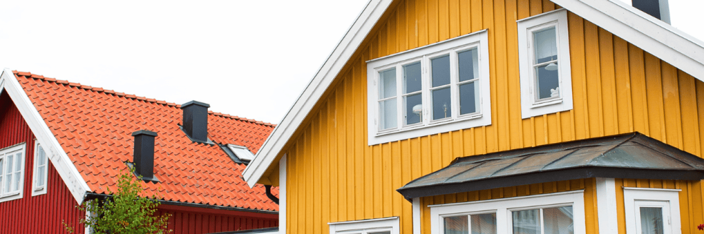 rott-hus-med-vita-knutar-och-ett-gult-hus-med-vita-knutar