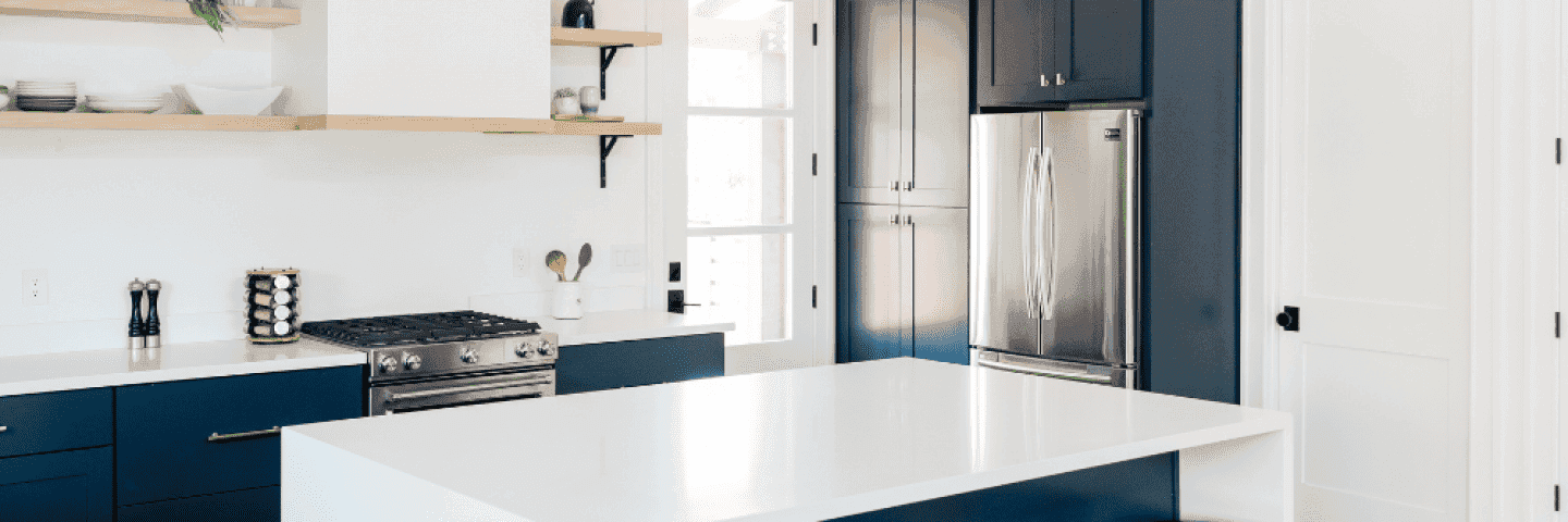 ett-vitt-kok-med-bla-luckor-och-kromad-kyl